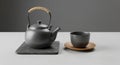 Ceramic teapot with a light brown handle is placed on a rectangular black slate. A matching ceramic Royalty Free Stock Photo