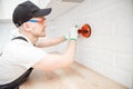 Ceramic tile with chamfer hands in process of laying white rectangular tiles on kitchen wall