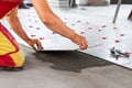 Ceramic Tiles. Tiler placing ceramic wall tile in position over adhesive with lash tile leveling system Royalty Free Stock Photo