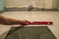 Ceramic tiles and tools for tiler. Worker hand installing floor tiles. Home improvement, renovation - ceramic tile floor adhesive, Royalty Free Stock Photo