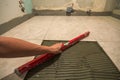 Ceramic tiles and tools for tiler. Worker hand installing floor tiles. Home improvement, renovation - ceramic tile floor adhesive, Royalty Free Stock Photo