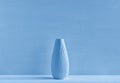 Ceramic vase on a blue background. The concept of minimalism. Close-up