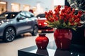 Ceramic vase holds fake red flowers on a glass table, showroom elegance.