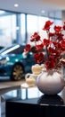 Ceramic vase holds fake red flowers on a glass table, showroom elegance.