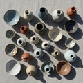 Of ceramic vases and bowls is arrayed on a textured light colored Royalty Free Stock Photo