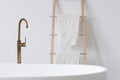 Ceramic white bathtub and towels in Scandinavian style bathroom Royalty Free Stock Photo