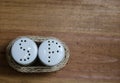 Ceramic and wicker salt and pepper shakers on wooden table Royalty Free Stock Photo