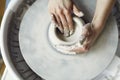 Ceramic working process with clay potter`s wheel, close-up of woman hands.