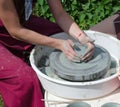 Ceramic workshop - the girl makes a pot of clay on a potter`s wheel. Hands closeup Royalty Free Stock Photo