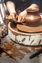 Ceramics. The master on the potter`s wheel produces a vessel of clay, undercutting the form.