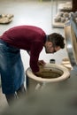 Ceramist Dressed in an Apron Placing Clay Sculpture in Electric Oven. Royalty Free Stock Photo