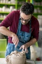 Ceramist Dressed in an Apron Sculpting Statue from Raw Clay in Bright Ceramic Workshop. Royalty Free Stock Photo