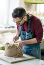 Ceramist Dressed in an Apron Sculpting Statue from Raw Clay in Bright Ceramic Workshop. Royalty Free Stock Photo