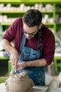 Ceramist Dressed in an Apron Sculpting Statue from Raw Clay in Bright Ceramic Workshop. Royalty Free Stock Photo