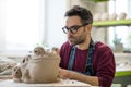 Ceramist Dressed in an Apron Sculpting Statue from Raw Clay in Bright Ceramic Workshop. Royalty Free Stock Photo