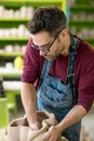 Ceramist Dressed in an Apron Sculpting Statue from Raw Clay in Bright Ceramic Workshop. Royalty Free Stock Photo