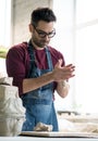 Ceramist Dressed in an Apron Working with Raw Clay in Bright Ceramic Workshop. Royalty Free Stock Photo