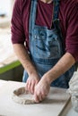 Ceramist Dressed in an Apron Working with Raw Clay in Bright Ceramic Workshop. Royalty Free Stock Photo