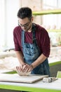 Ceramist Dressed in an Apron Working with Raw Clay in Bright Ceramic Workshop. Royalty Free Stock Photo