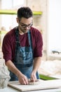 Ceramist Dressed in an Apron Working with Raw Clay in Bright Ceramic Workshop. Royalty Free Stock Photo