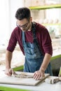 Ceramist Dressed in an Apron Working with Raw Clay in Bright Ceramic Workshop. Royalty Free Stock Photo