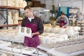 Ceramist explaining process of forming ceramic dishes in slipcasting molds Royalty Free Stock Photo