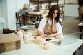 Ceramist with laptop working in studio, making notes Royalty Free Stock Photo