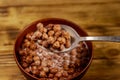 Cereal chocolate balls with milk in a bowl on wooden table. Spoon with breakfast Royalty Free Stock Photo