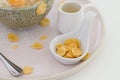 Cereal corn flakes in white blow putting near a dish of dessert, Royalty Free Stock Photo