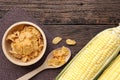 Cereal corn flakes in wooden bowl and corncobs on table. Royalty Free Stock Photo