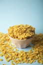 Cereal cornflakes for breakfast in a pink bowl on a blue background. Minamal art creative food concept