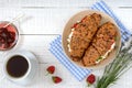 Cereal croissants with cream cheese and fresh strawberries, cup of tea and jam Royalty Free Stock Photo