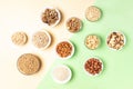 Cereal grains and nuts in bowls on two-tone beige-green background. View from above Royalty Free Stock Photo