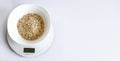 Cereal and a kitchen scale on the white background Royalty Free Stock Photo