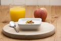 Cereal with yogurt and orange juice with apple
