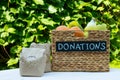 Various food in a box for donations on a table on a background of greens. Charity and donation concept, copy space. Royalty Free Stock Photo