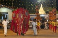 A ceremonial elephant dressed in a beautiful red cloak is led through the parade at the Kataragama Festival in Sri Lanka.