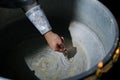 Closeup view to the priest hand holding cross and baptismal font with water