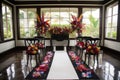ceremony setup with elegant white chairs, black bows and colorful floral bouquets