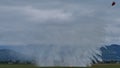 Cloud of water dropped from a helicopter over a forest fire