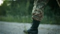 Certain military man walking across sandy road