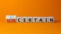 Certain or uncertain symbol. Turned wooden cubes and changed the concept word uncertain to certain. Beautiful orange table, orange Royalty Free Stock Photo