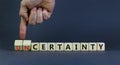 Certainty or Uncertainty symbol. Businessman turns wooden cubes and changes concept words Uncertainty to Certainty. Beautiful grey