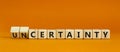 Certainty or Uncertainty symbol. Turned wooden cubes and changed concept words Uncertainty to Certainty. Beautiful orange