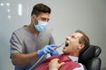 Certified dentist treating his patient at the clinic