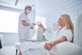 Certified female specialist in medicine mask helping to patient in the beauty clinic Royalty Free Stock Photo