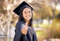 Certified goal getter. a young woman showing thumbs up on graduation day.