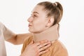Cervical collar. Traumatologist puts cervical soft collar or neck brace bandage on young woman to support and immobilize