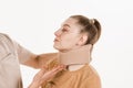 Cervical collar. Traumatologist puts cervical soft collar or neck brace bandage on young woman to support and immobilize