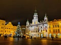 Historical city hall with decorated Christmas tree during dark December evening